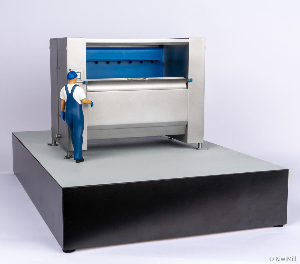 Eye-level front three-quarter view of the belt chiller model, operator at the touchscreen beside the rounded front lip